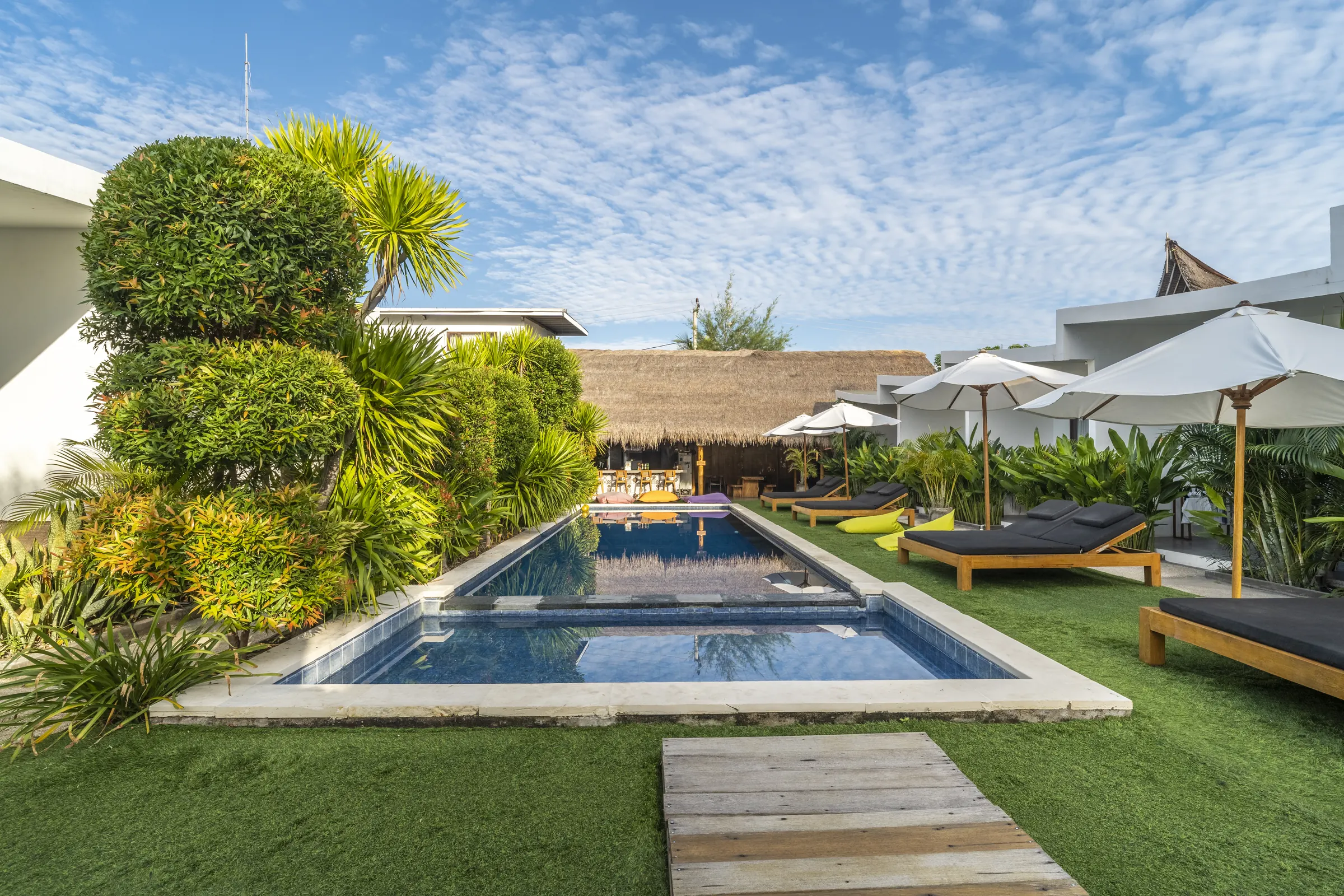 Sun loungers beside the pool in JAGO's tropical garden